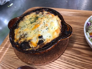 グラタン皿で黒カレーの上にチーズ、生たまごをトッピングしオーブンで焼きます。あっつあつで、とろけるチーズとタマゴでマイルドな味わいです。